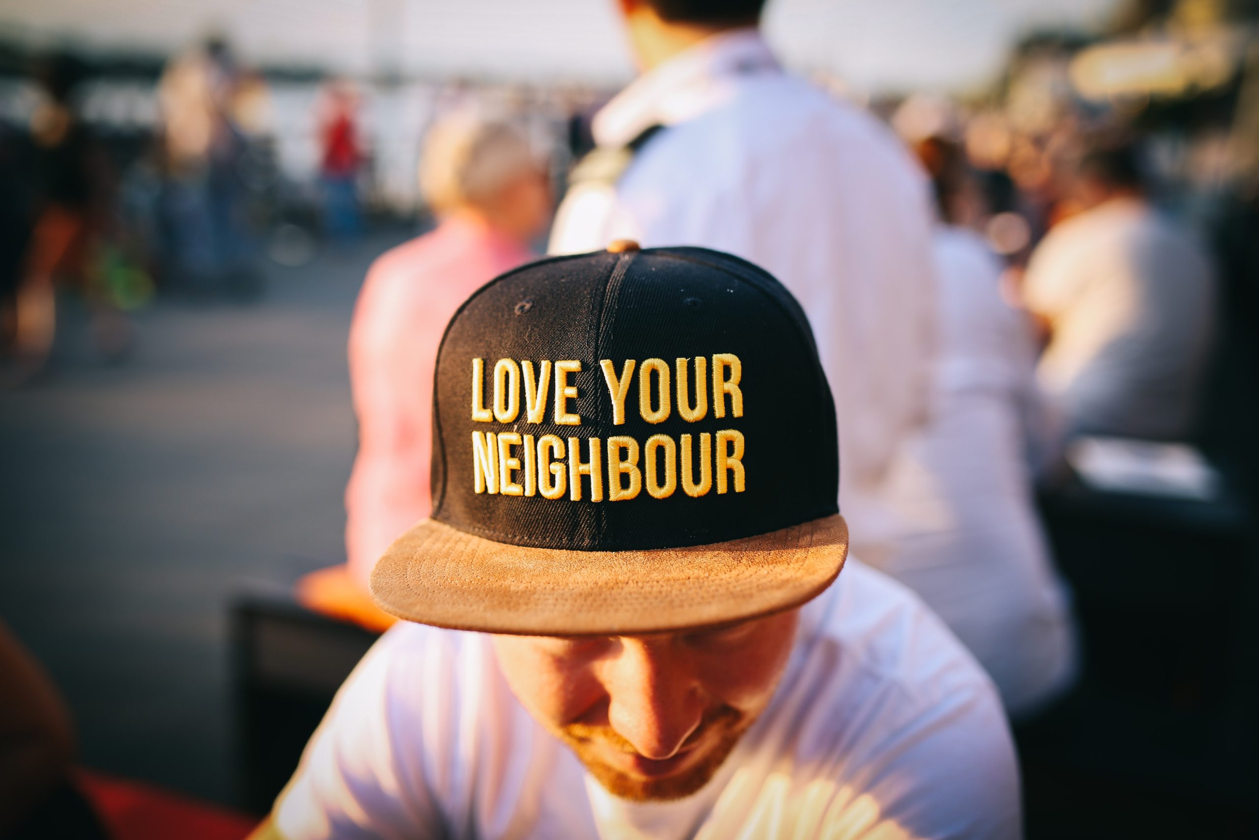 man wearing "love your neighbour" hat